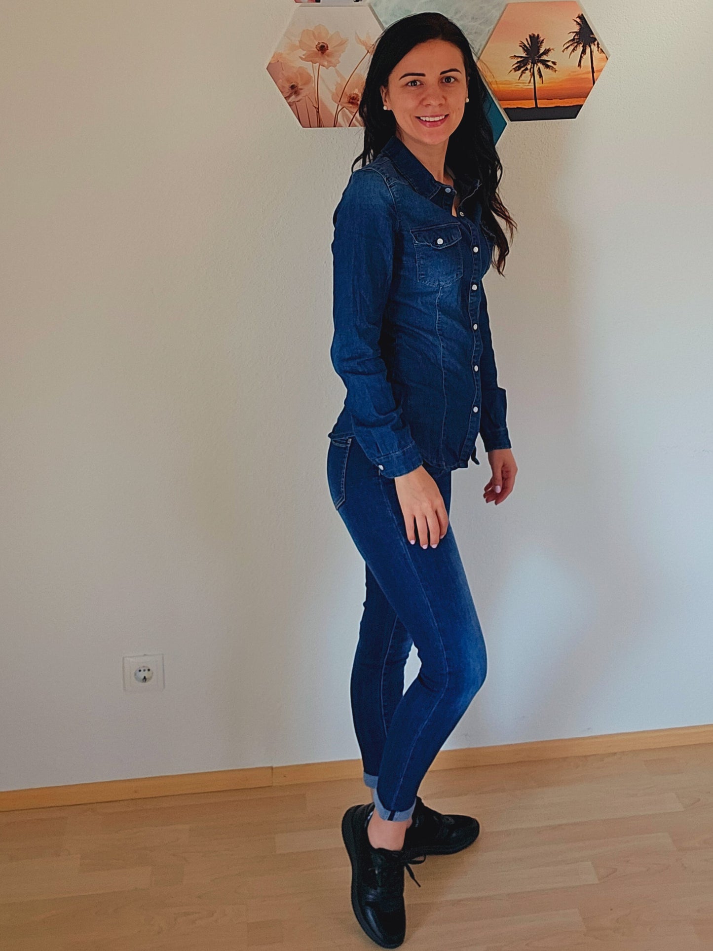 Das Model trägt eine dunkelblaue Jeansbluse mit Knopfleiste und Brusttaschen.