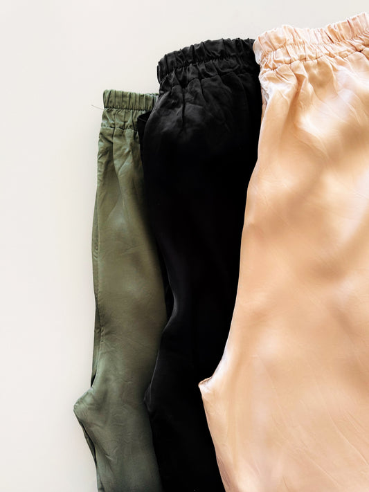 3 Satin Hose (Beige, Olive und Schwarz) flatlay artig fotografiert.
